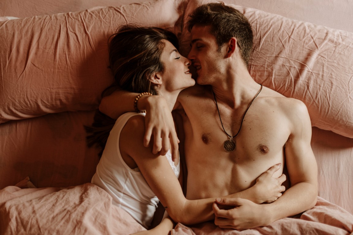 Kobieta i mężczyzna całujący się w łóżku 